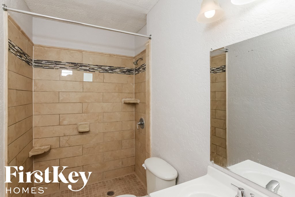 a bathroom with a toilet and a sink and a shower