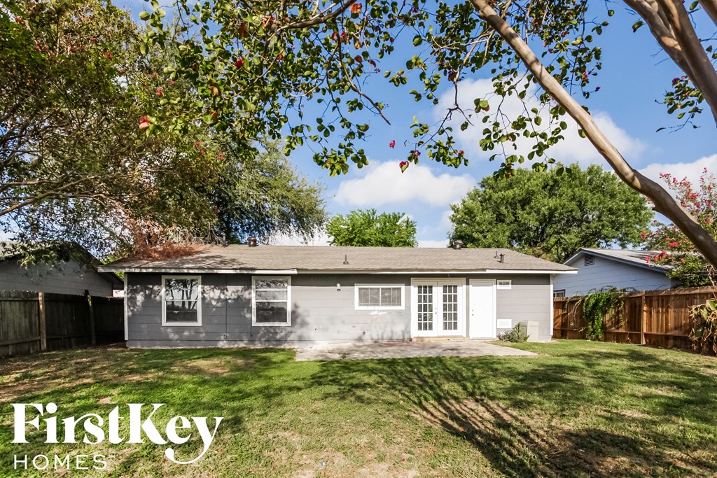 a small white house with a yard and a tree