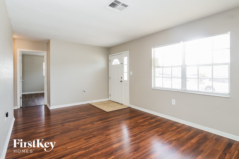 A room with wooden floors and a window letting in light.