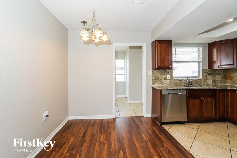 A kitchen with wooden floors and a stainless steel dishwasher.