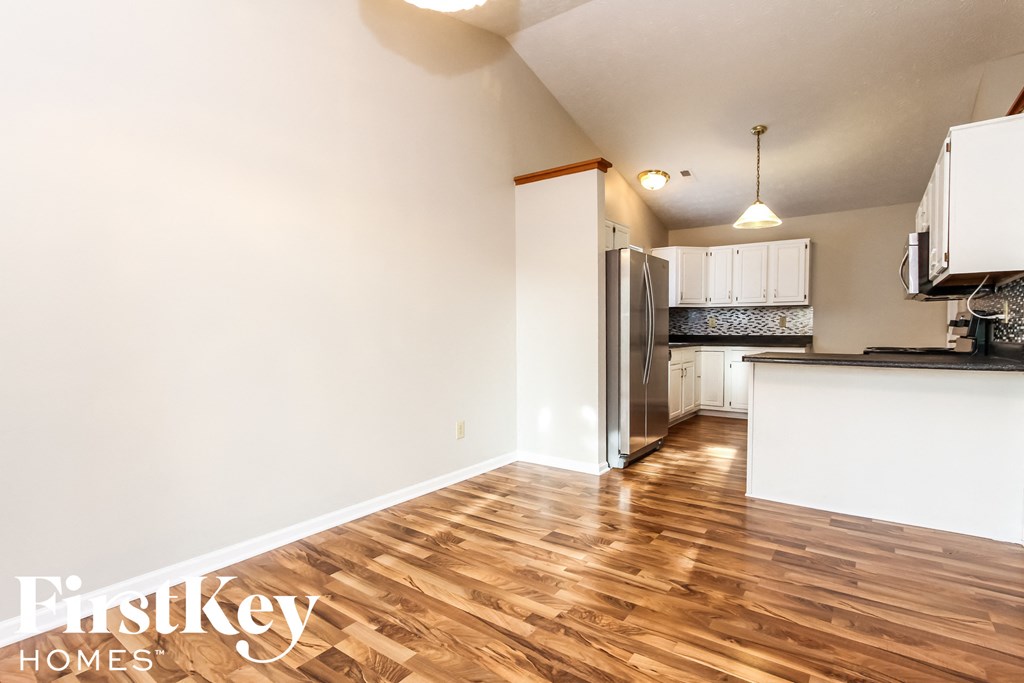 A kitchen with wooden floors and a refrigerator.