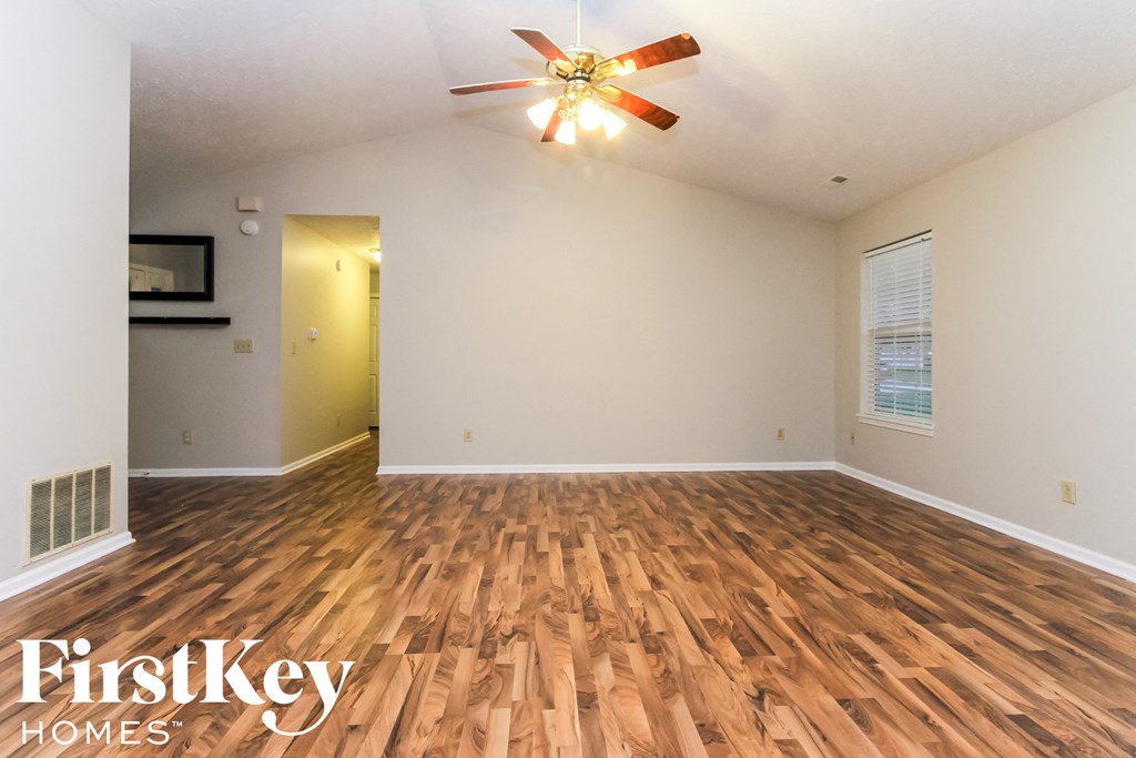 A room with wooden flooring and a ceiling fan.