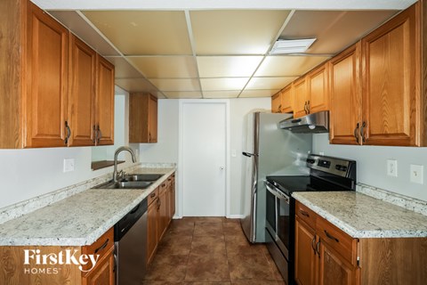 A kitchen with wooden cabinets and a refrigerator.