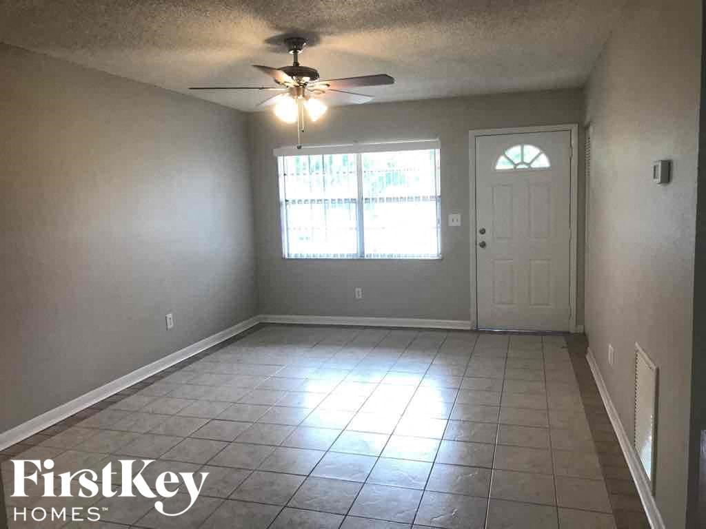 A room with a ceiling fan and a door.