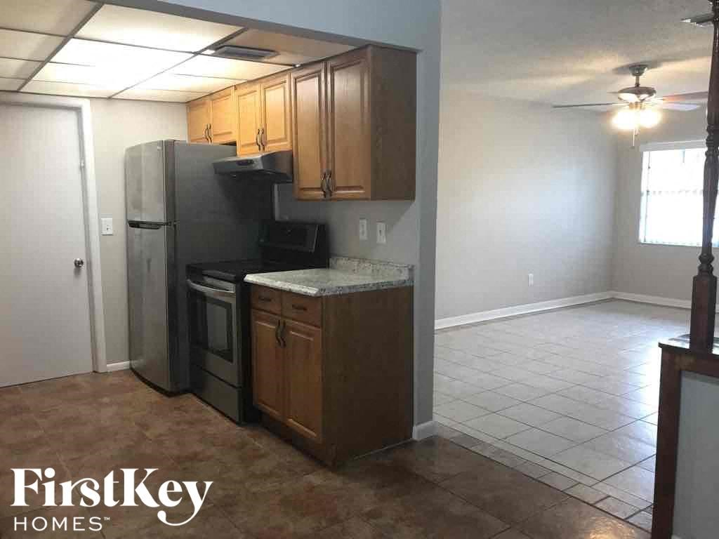 A kitchen with a refrigerator, oven, and microwave.