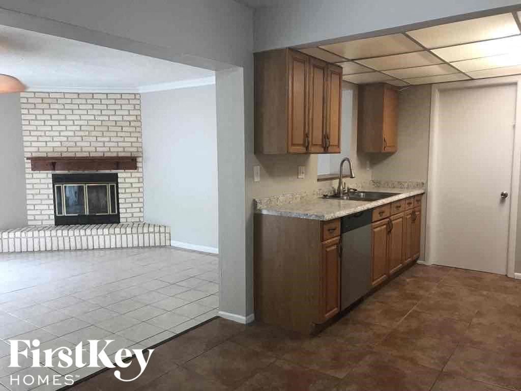 A kitchen with a fireplace and a tiled floor.