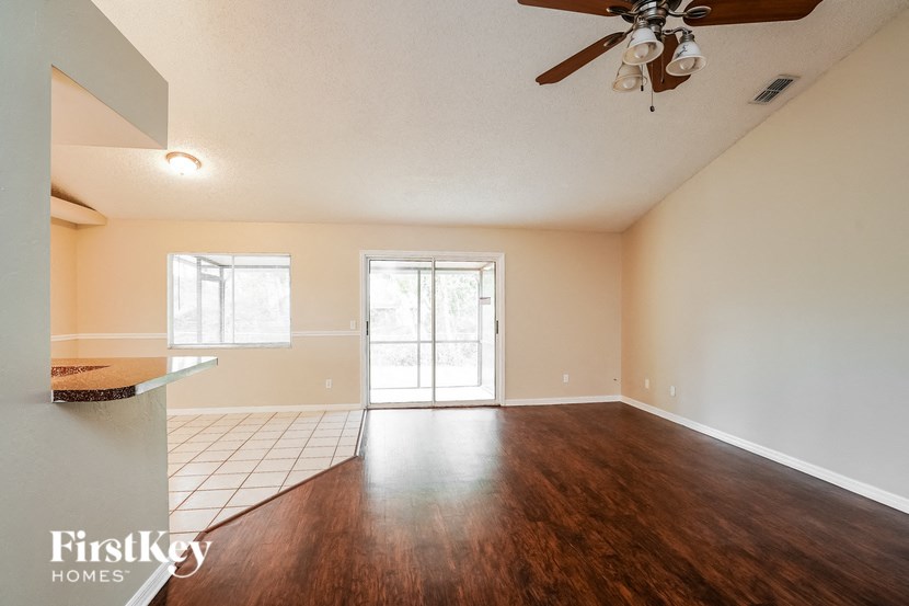 A room with a ceiling fan and a large window.