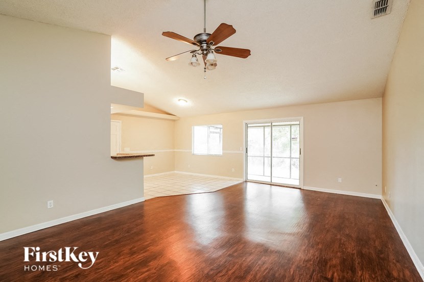 A room with a ceiling fan and wooden flooring.