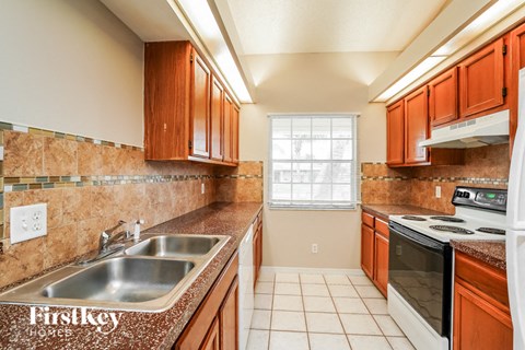 A kitchen with brown cabinets and a stove top oven.