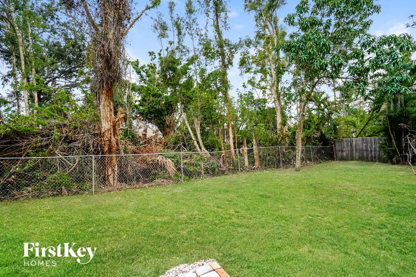A backyard with a fence and trees.