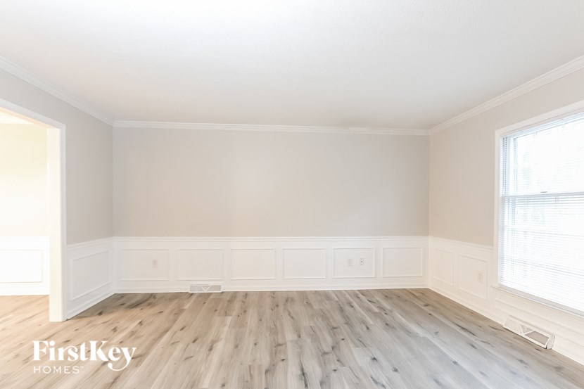 A room with wooden flooring and white walls.