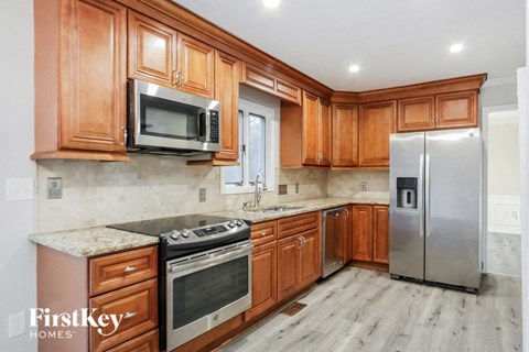 A kitchen with wooden cabinets and a stainless steel refrigerator.