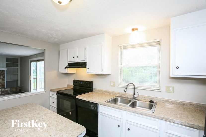 a kitchen with black appliances and white cabinets