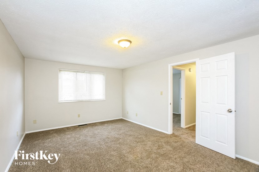 a bedroom with carpet and a door to a closet