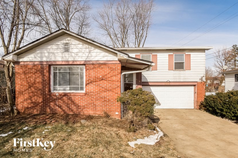A brick house with a garage is for sale.