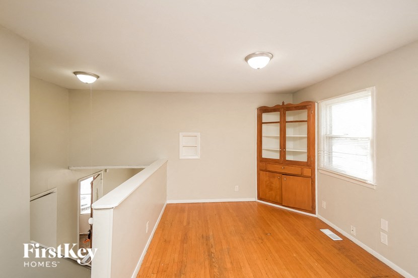 A room with wooden floors and a white ceiling with a light fixture.