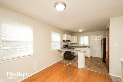 A kitchen area with a refrigerator, sink, and cabinets.