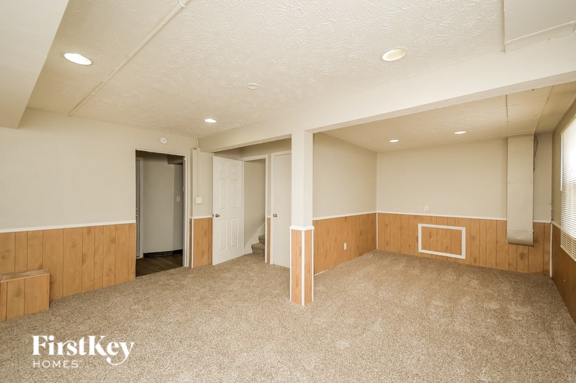 A large empty room with a carpeted floor and white walls.