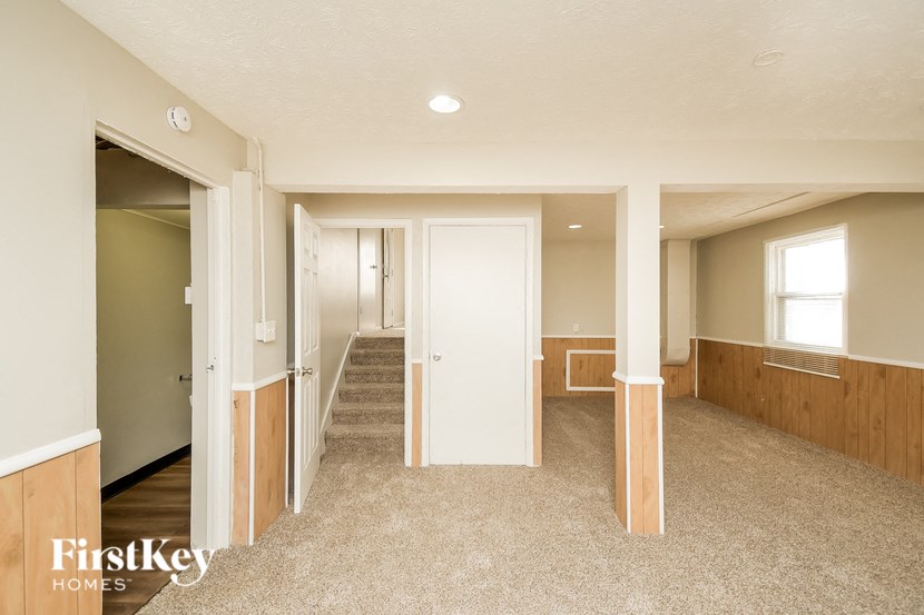A spacious room with a staircase leading to another level.