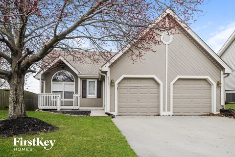 the front of a house with two garages and a sidewalk