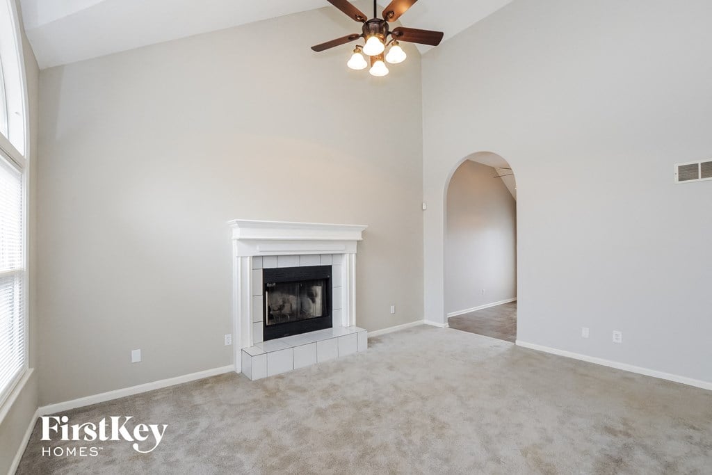 a living room with a fireplace and a ceiling fan