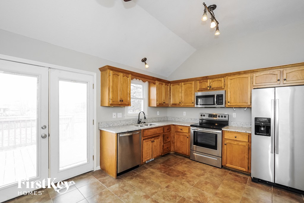a kitchen with wooden cabinets and stainless steel appliances