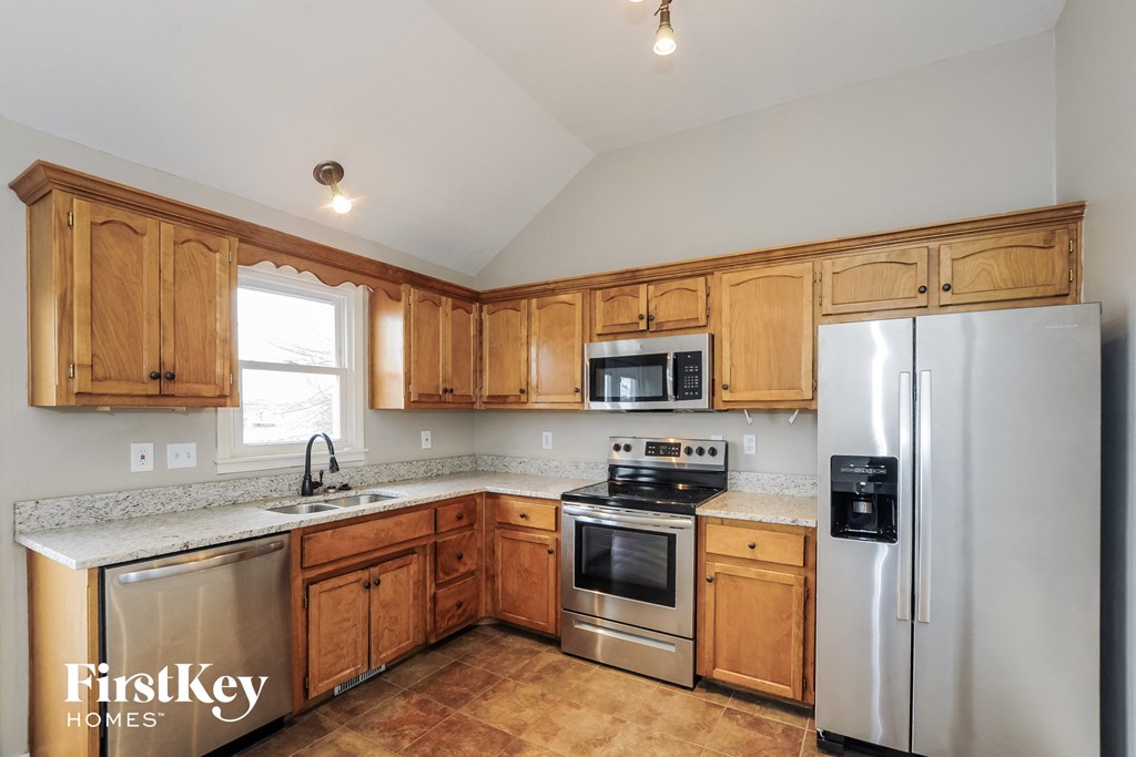 the kitchen is updated with stainless steel appliances and wooden cabinets