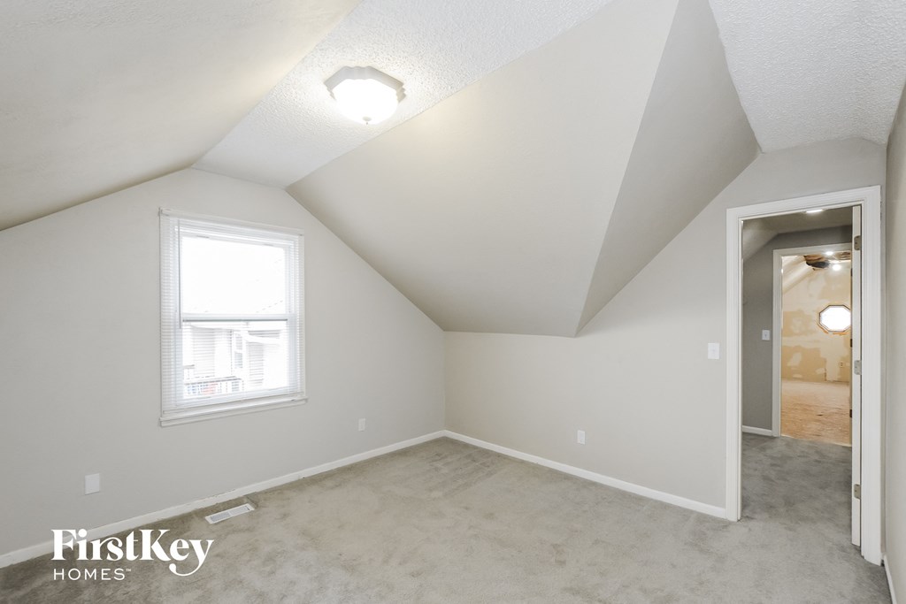 the living room of an attic with a door and a window