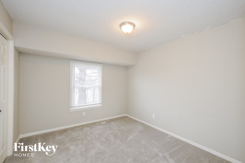 a bedroom with a carpeted floor and a window