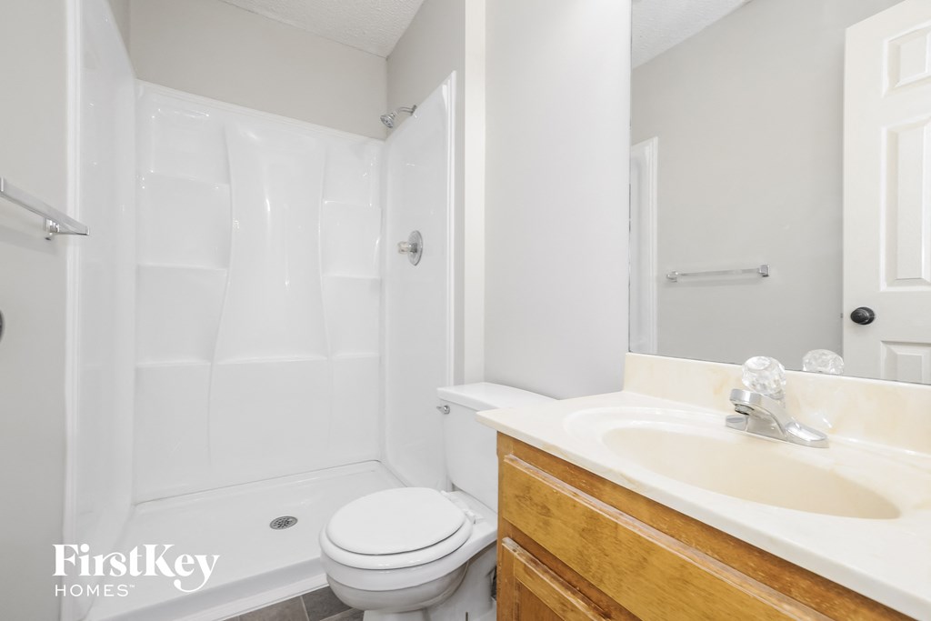 a white bathroom with a sink toilet and shower