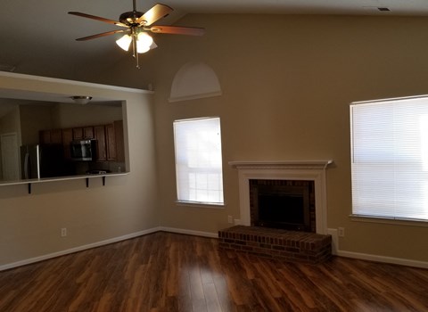 a living room with a fireplace and a ceiling fan