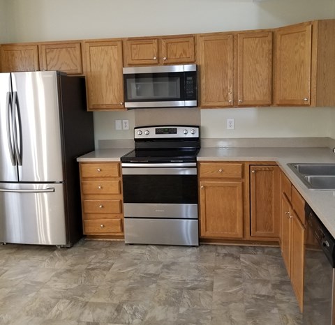 a kitchen with stainless steel appliances and wooden cabinets