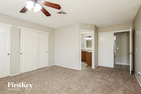 a living room with carpet and a ceiling fan
