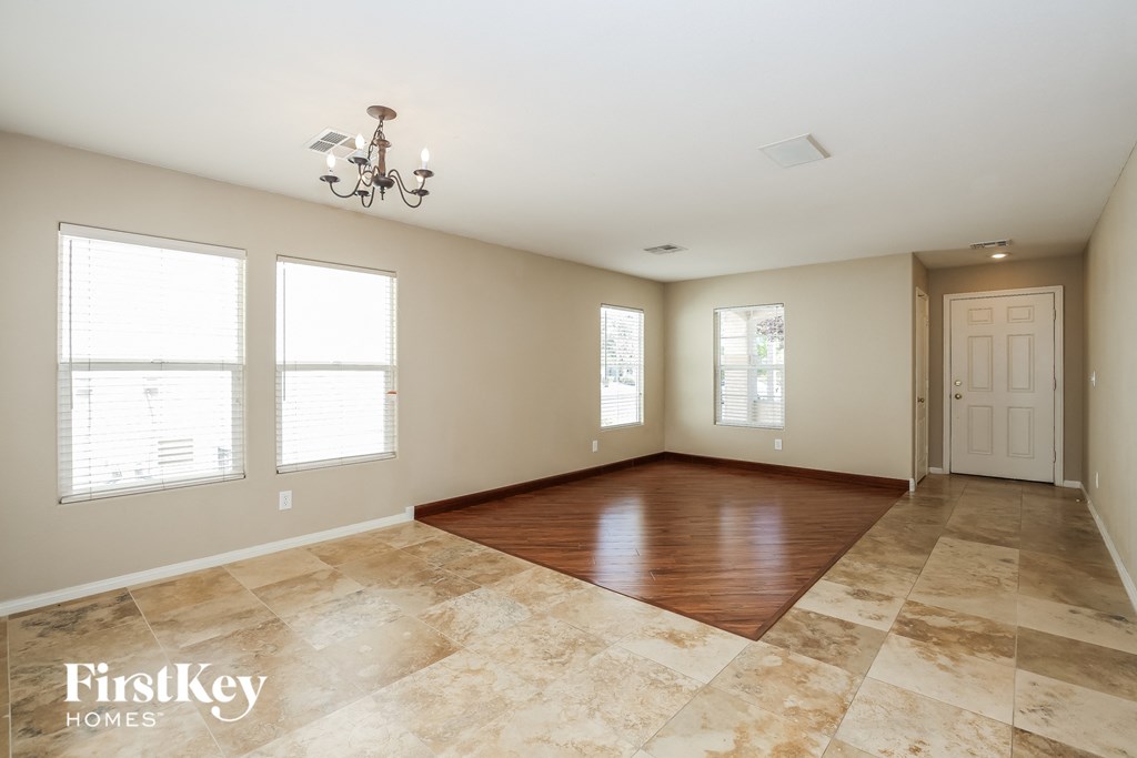 A spacious room with a marble floor and a chandelier.