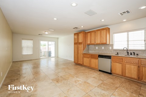 A kitchen with wooden cabinets and a tiled floor.