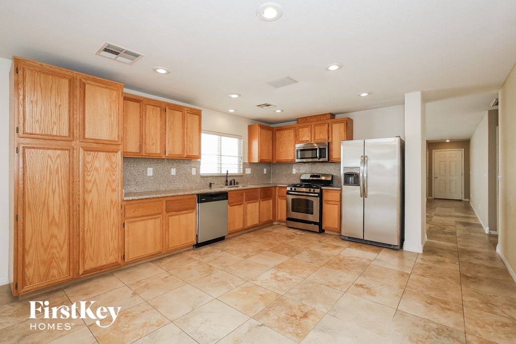 A kitchen with wooden cabinets and tile flooring.