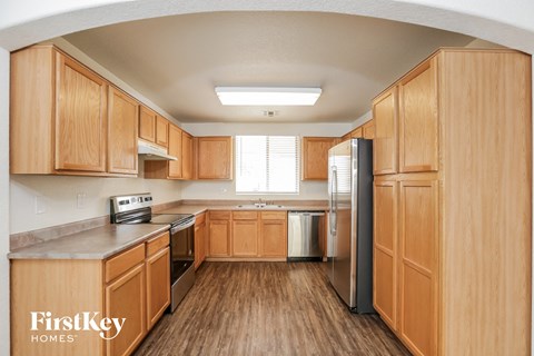 A kitchen with wooden cabinets and a stainless steel refrigerator.
