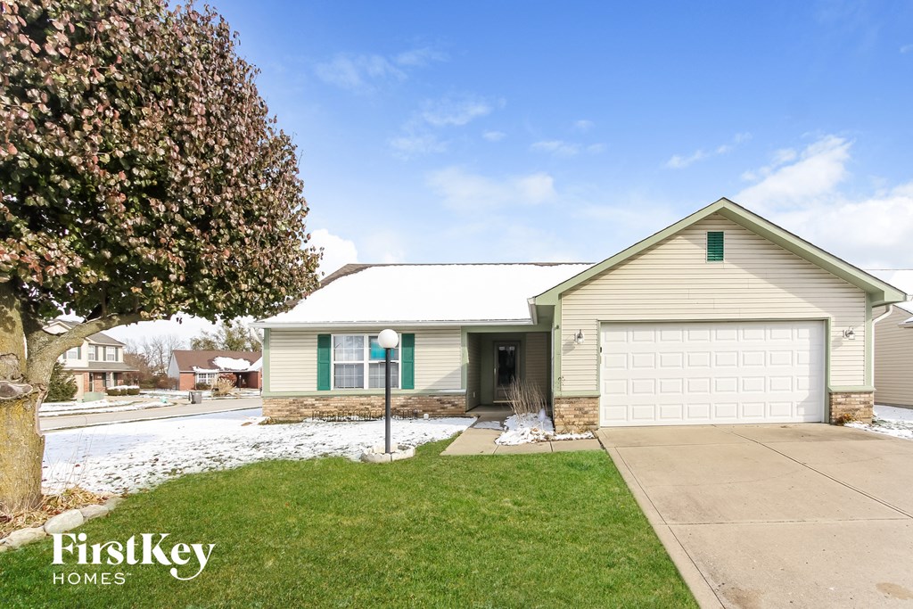 a white and green house with a white garage door