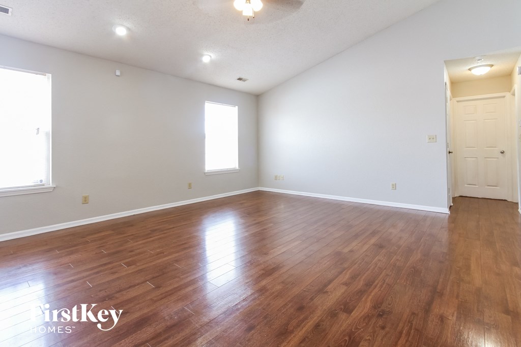 the living room and dining room with hardwood floors and white walls