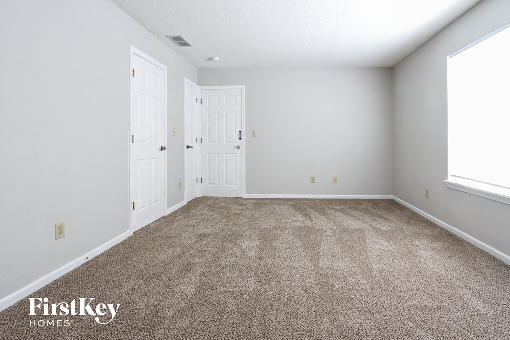 a empty room with carpet and white doors
