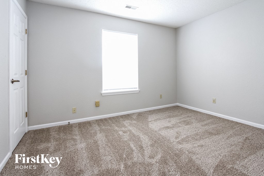 an empty room with carpet and a window
