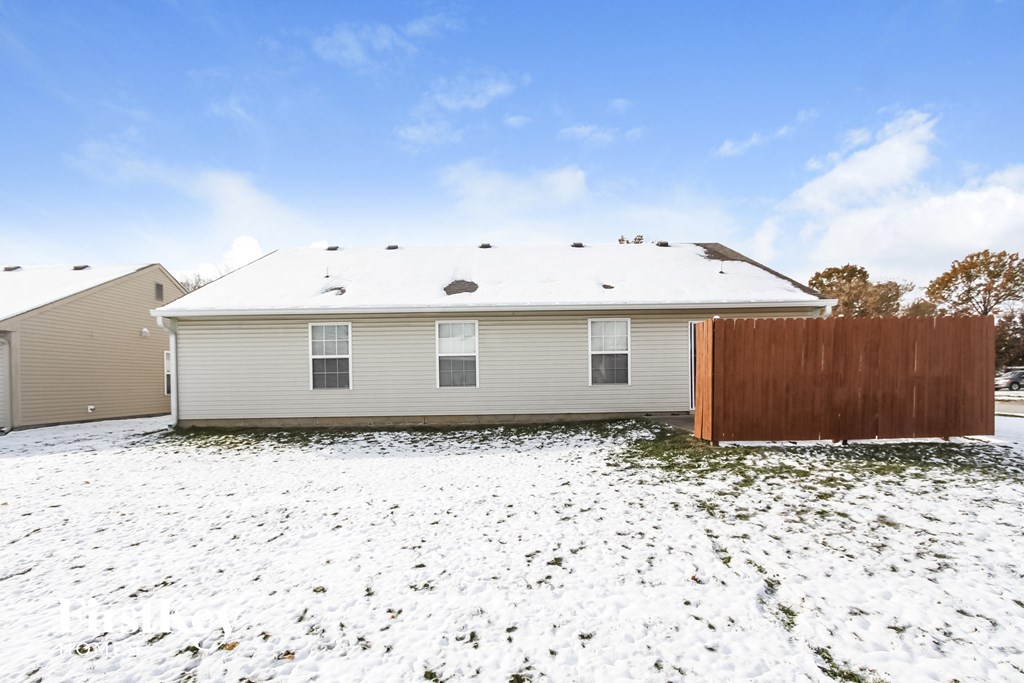 a home with a wooden fence in the snow
