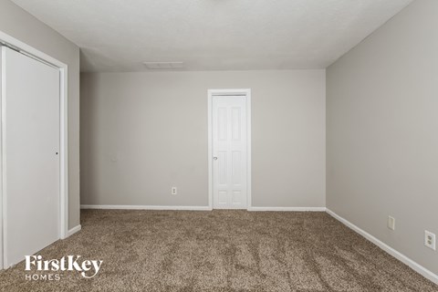 a bedroom with carpet and a white door