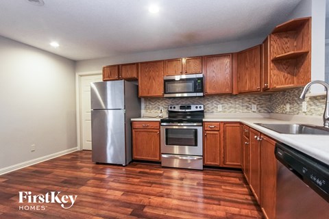 A kitchen with wooden cabinets and a stainless steel refrigerator.