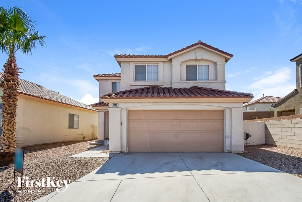 a house with a garage door and a palm tree