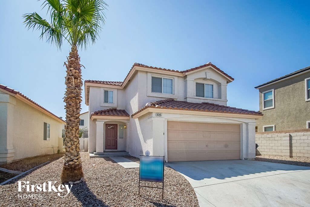 a home with a palm tree and a garage door