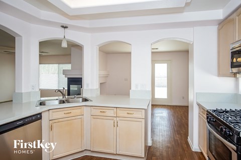 a kitchen with wooden floors and white cabinets
