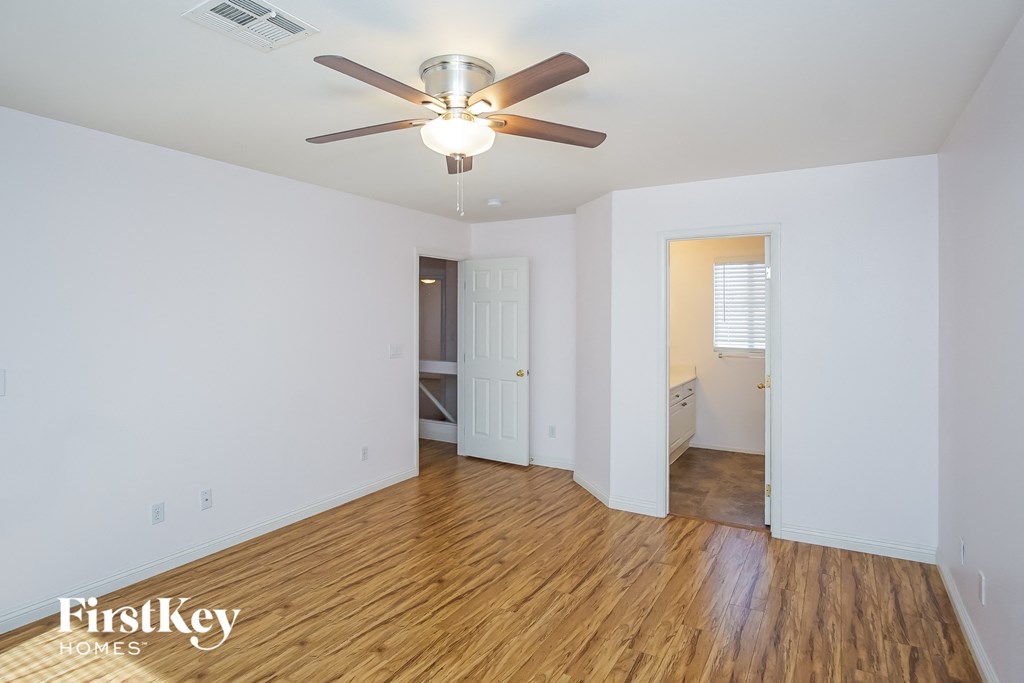 a living room with wood floors and a ceiling fan
