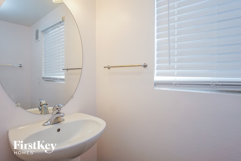 a bathroom with a sink and a mirror and a window