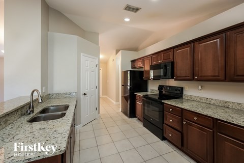 a kitchen with granite counter tops and black appliances